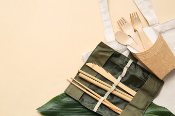 Eco cutlery and bag on color background