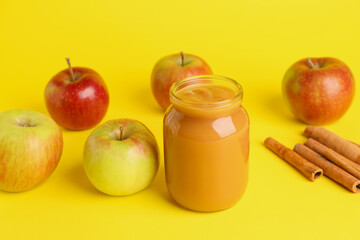 Jar with sweet apple jam on color background