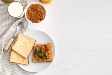 Toast with sweet apple jam in plate on light wooden background