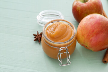 Jar with sweet apple jam on color wooden background