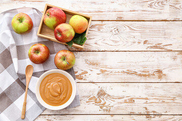 Bowl with sweet apple jam on wooden background
