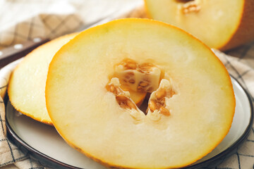Plate with sweet cut melon on light background