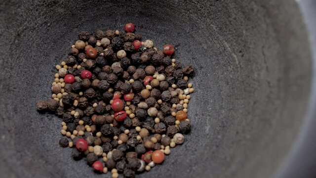 pouring pepper peppercorns into stone mortar 4k