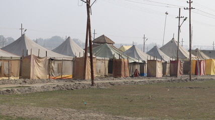 Fototapeta na wymiar Allahabad, Uttar Pradesh India- February 09 2021: Plain white tents placed next to each other at the holy Ganga camp for pilgrims.