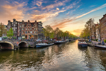 Fototapeta premium Amsterdam Netherlands, sunset city skyline of Dutch house at canal waterfront