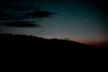 Sunset with moon in the mountains.