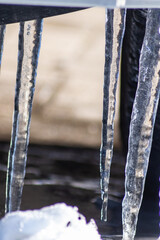 Long icicles melting in winter and spring from December to January  as frozen water with frosty ice as slippery crystals on urban streets and beautiful winter scenery show need for weather insurance