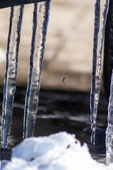 Long icicles melting in winter and spring from December to January  as frozen water with frosty ice as slippery crystals on urban streets and beautiful winter scenery show need for weather insurance