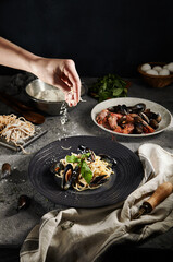Home made pasta with seafood and green leaf. Gray vintage table and cloth. Tasty pasta with mussels