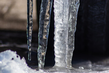 Long icicles melting in winter and spring from December to January  as frozen water with frosty ice as slippery crystals on urban streets and beautiful winter scenery show need for weather insurance