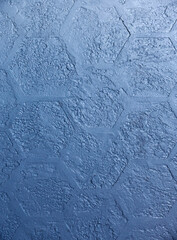 Wall surface or object decorating by decorative stucco. Plaster structure in the form of blue honeycombs. Building material for modern interior walls.