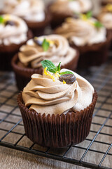 Homemade chocolate cupcakes with tiramisu cream, chocolate coffee beans and mint.