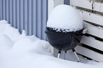 a barbecue that has been covered in snow