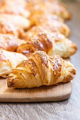 Homemade croissants with cheese on wooden board. Baking for breakfast.