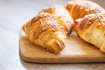 Homemade croissants with cheese on wooden board. Baking for breakfast.