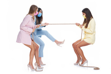 Three women in pastel suits pulling rope over white background