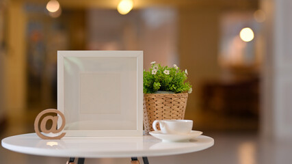 Coffee table with coffee cup, plant pot and mock up frame