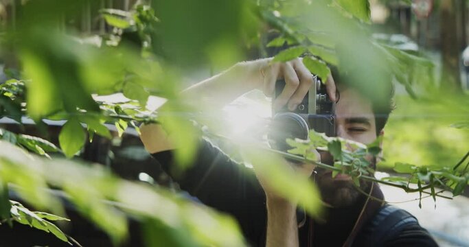 Man taking pictures of leaves on a tree