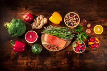 Fototapeta na wymiar Healthy food, shot from above. Salmon, asparagus, and other superfoods on a dark rustic wooden background. Balanced diet