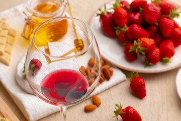 Glass of red wine with appetizer on table close up