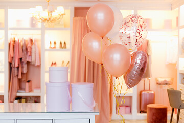 Pink round gift boxes and balloons in the dressing room in delicate pastel peach shades