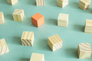 Group of wooden blocks and one different color block on green background. Different opinion, direction, idea, innovation concept