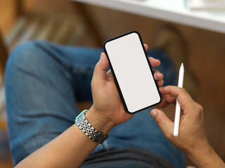 Male holding smartphone include clipping path screen and stylus pen in his hand