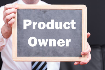 Produktmanager in einem Unternehmen hält eine Tafel hoch auf der Product Owner steht