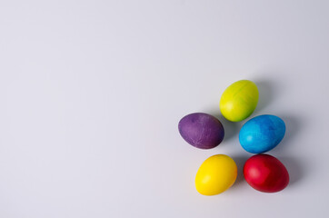 Easter background. Painted chicken eggs in yellow, green, blue, red, purple colors lie on a light background. Step 5