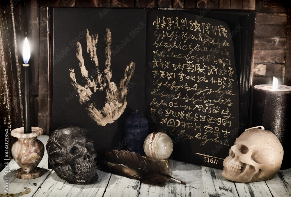 Wall mural evil book wih black pages and mystic symbols, burning candles and skull on wooden table. sell soul t