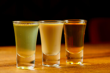 Fresh organic apple cider with apples and cinnamon over rustic wooden background. Close up three glasses.