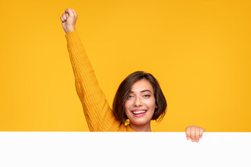 Cheerful woman with banner raising fist