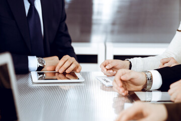 Business people working together at meeting in modern office. Unknown businessman and woman with colleagues or lawyers at negotiation about contract