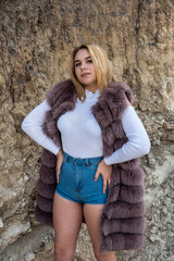 pretty girl in casual cloth and fur coat sand rocks