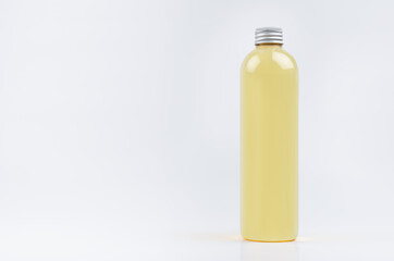 Transparent plastic tall thin bottle with orange drink, cooking oil or cosmetic produce, silver cap mockup on white background. Template for design.