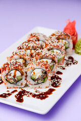 Japanese sushi set with eel and unagi sauce. Cream cheese inside. Served on a white plate.