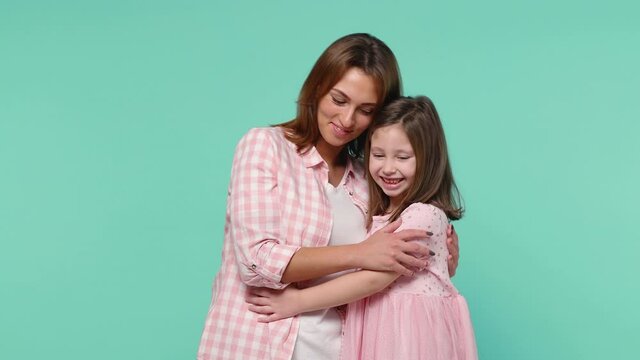 Happy woman in pink clothes have fun with cute child baby girl 5-6 years old. Mommy little kid daughter hugs isolated on pastel blue background studio. Mother's Day family parenthood childhood concept