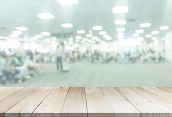 blured airport with wooden perspective table for add text or products in the presentation. abstract people passengers at station aerodrome interiors. transportation or business concept.