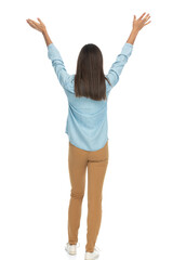 casual woman walking away and raising her arms