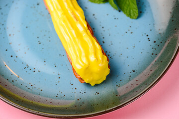 Tasty eclair with vanilla filling over pink background. French cuisine concept, dessert for tea or...