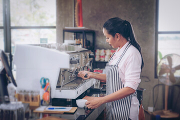 Woman cafe owner in apron looking at camera and smiling.