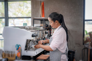 Woman cafe owner in apron looking at camera and smiling.