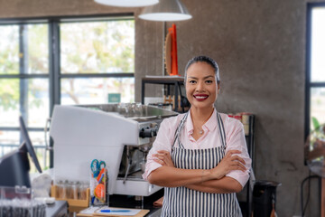 Fototapeta premium Woman cafe owner in apron looking at camera and smiling.