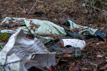 Pollution of nature with old unnecessary clothes discarded in the forest