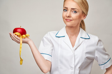 nutritionist doctor healthy lifestyle concept - holding organic red apple and measure tape