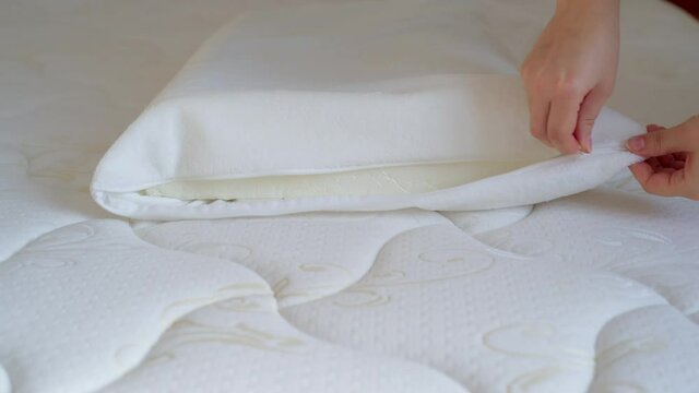Women's hands put a cover on the orthopedic pillow. Protecting the foam pillow from moisture