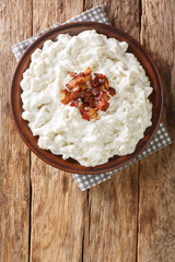 Bryndzove halusky The National Dish of Slovakia closeup in the plate on the table. Vertical top view from above