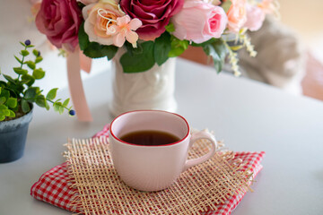 Coffee Break Time. A cup of coffee, and Rose Flower vase place on white home office.
