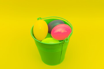 Easter plastic eggs in a metal green bucket indoors studio shot.