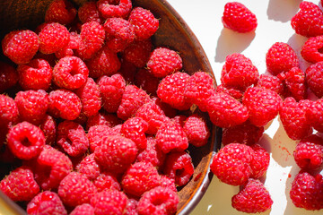 Red ripe and juicy raspberry in an inverted small bowl
